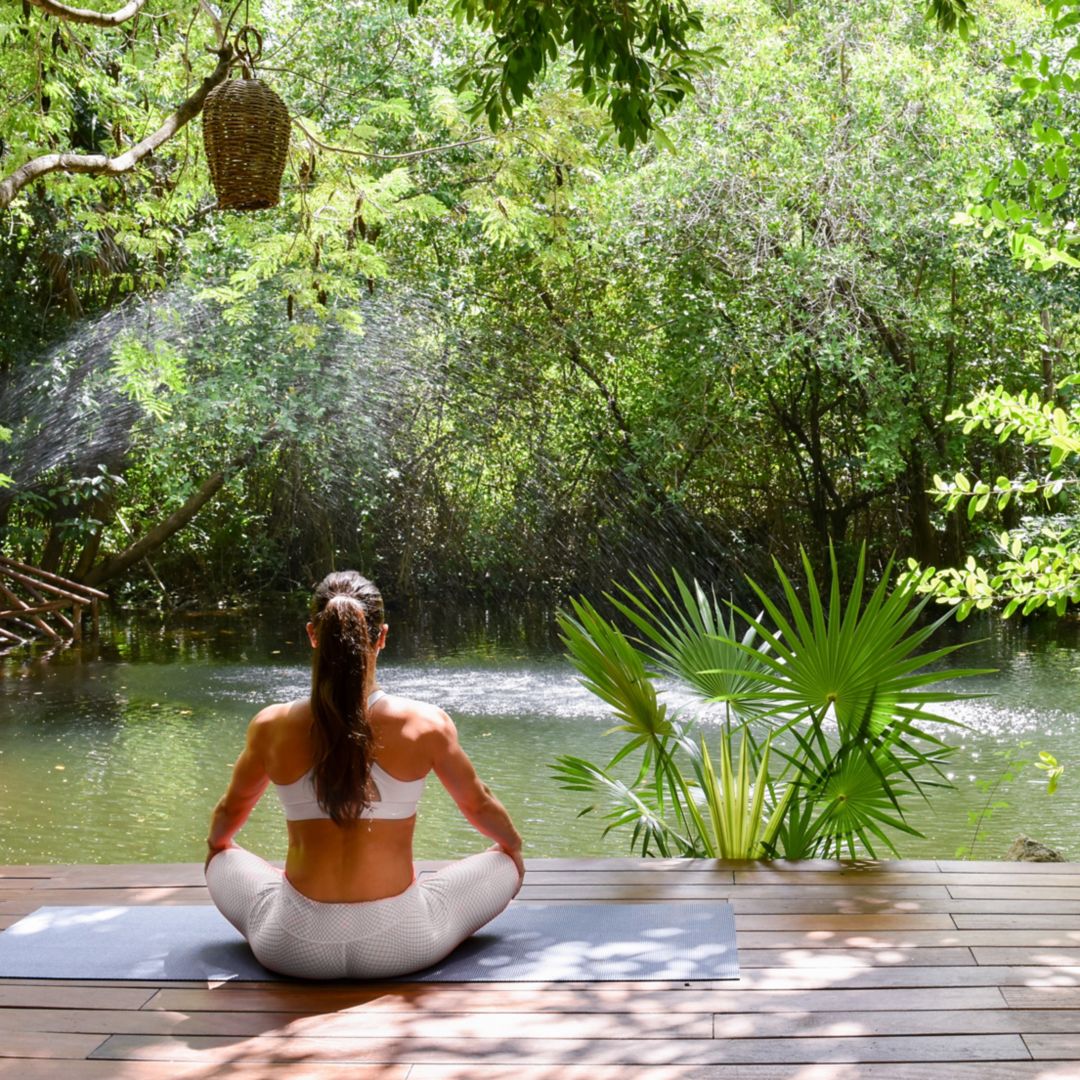 women in white dress kneeling with ceremonial drums and incense smoke for Rosewood Mayakoba's Marry Oneself Ceremony at Sense Spa